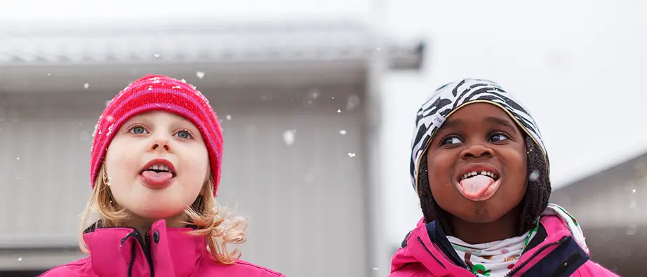 Två tjejer som försöker fånga snöflingor